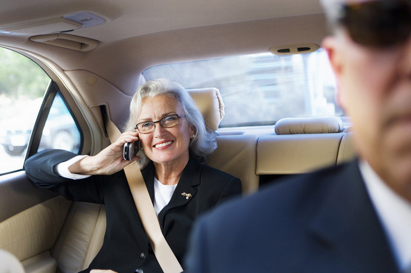 Ältere Frau im Auto am Telefon