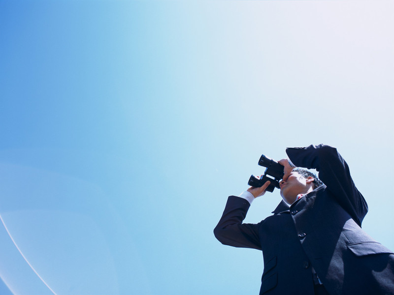 Mann mit Fernglas schaut hoch