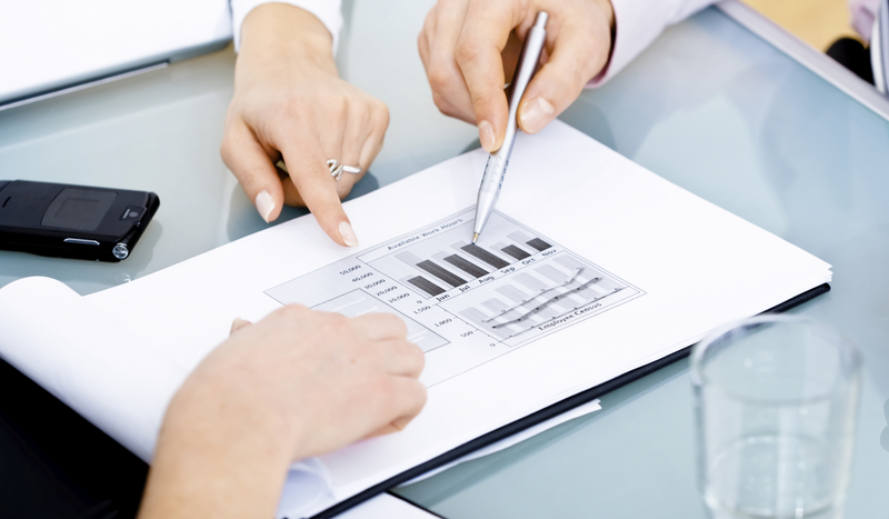 Hände zeigen auf Diagramm